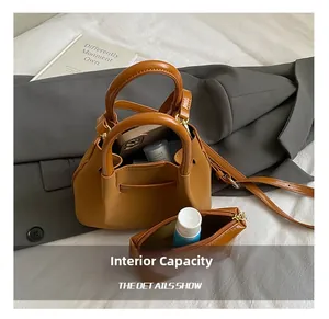 Détail de la capacité intérieure du sac seau en daim avec téléphone et crème de soin