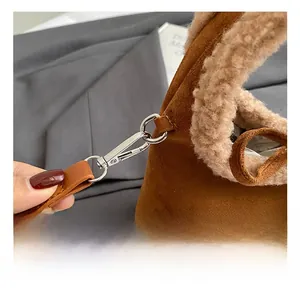 Detail view of silver metal hook and plush lamb wool trim on vintage brown suede handbag