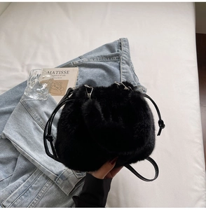 Détail de la texture en fausse fourrure noire et cordon de serrage du sac à bandoulière