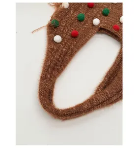 Detail of wide knitted shoulder strap in dark brown with colorful plush pom-poms