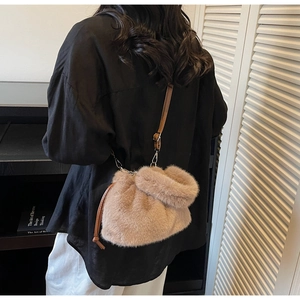 Vue de mannequin d'un sac seau en peluche beige avec cordon et bandoulière marron