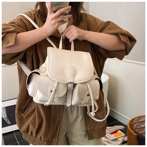 Detail view of cream white PU leather backpack featuring metal buckle and side flap pockets