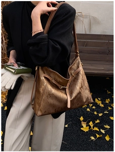 Detail of vintage metallic shoulder bag with bronze texture and golden metal hardware