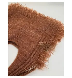 Macro detail of brown chunky knit fabric showing the long tassel fringe texture