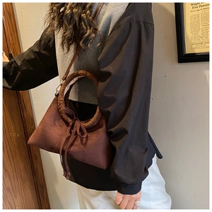 Detail of dark brown suede handbag with plush ring handle and warm autumn vintage style