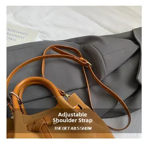 Détails montrant la bandoulière réglable du sac à main en similicuir caramel