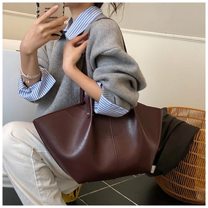 Detail of burgundy wing tote bag in matte leather showing spacious interior and sleek straps