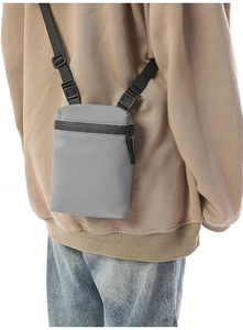 Detail of grey crossbody bag featuring waterproof zipper and adjustable nylon strap
