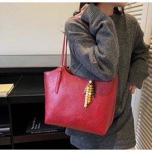 Dettaglio borsa tote in pelle rossa vintage con elegante nappa di perline colorate