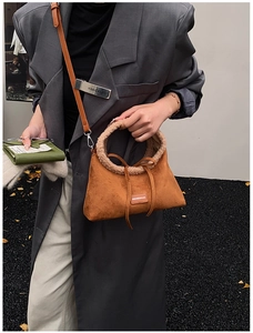 Close-up of caramel suede handbag with plush shearling trim and slim leather strap