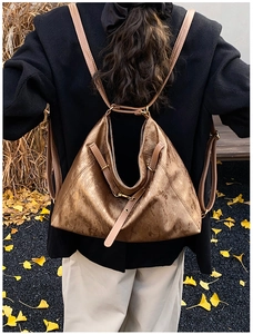 Detail of a bronze textured tote bag with unique triangular design and slim straps