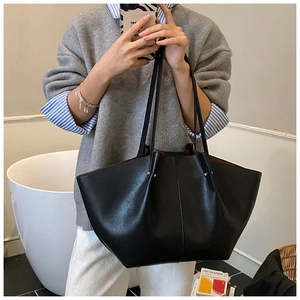 Detailed view of spacious black leather tote bag with contrasting reddish-brown lining