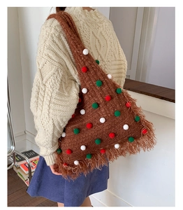 Detail of knit Christmas tree shoulder bag with colorful plush balls and long tassels