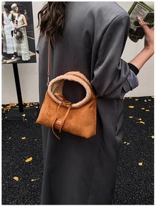 Brown suede handbag with faux shearling trim and bow detail for winter fashion style