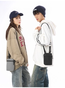 Detail showing grey and black nylon crossbody phone bags with adjustable straps