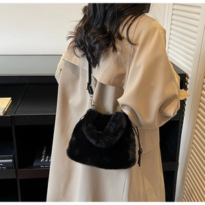 Détail d'un sac bandoulière en peluche noire avec fausse fourrure douce et sangle en cuir