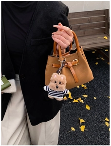 Détail du sac à main en cuir PU marron avec breloque ours en peluche dans un parc d'automne