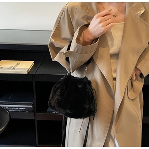 Détail du sac seau en fausse fourrure noire avec cordon de serrage et boucle métal