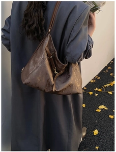 Detailed view of the brown vintage tote bag texture with brass hardware on a model