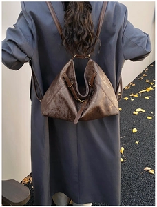 Deep brown irregular triangle backpack in vintage faux leather on a casual outdoor model