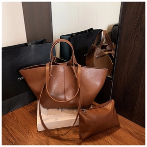 Close-up of brown faux leather tote bag and zipper pouch set with stitching details