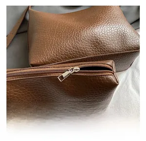 Detail of coffee brown lychee leather tote bag with silver metal zipper craftsmanship