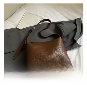 Detail of dark brown lychee texture leather and adjustable strap with silver buckle
