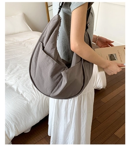 Detail of dark grey nylon crescent bag showing fabric texture and adjustable strap