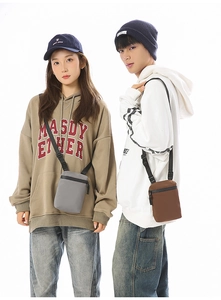 Close-up of gray and brown crossbody bags in durable nylon with adjustable straps