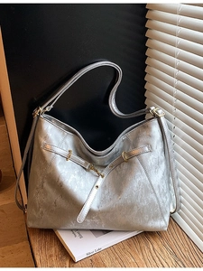 Silver metallic tote bag with cracked texture and gold hardware in a modern setting