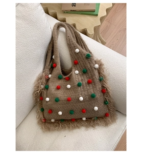 Détail d'un sac cabas en maille marron avec pompons colorés et franges latérales