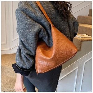 Detail of caramel brown leather tote with pebble texture shown from a side-back angle