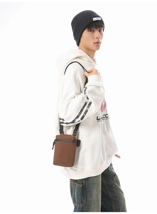 Detail view of small brown crossbody bag featuring durable nylon fabric and adjustable strap
