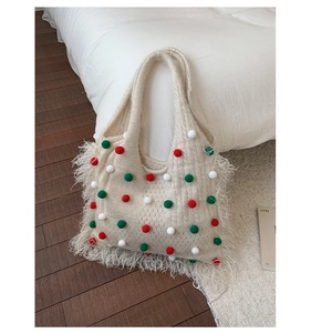 Détail du sac cabas en maille avec pompons colorés festifs et finitions à longues franges