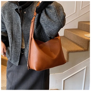 Macro detail of brown leather texture and adjustable strap on large tote bag