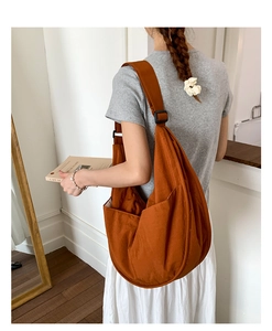 Detail of caramel hobo bag featuring side pocket, adjustable strap and large capacity