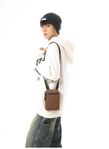Detail view of a men's dark brown waterproof crossbody bag with adjustable strap