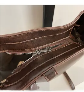 Détails de sac seau en similicuir marron foncé avec fermeture éclair métallique lisse