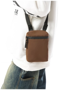 Detail of a brown crossbody phone bag with waterproof zippers and adjustable strap