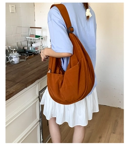 Detail view of large caramel nylon crossbody bag with side pocket and adjustable strap