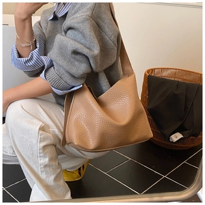 Detail of camel brown tote bag with ostrich texture shown in a modern interior setting