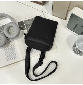 Minimalist black nylon crossbody phone bag with adjustable strap and premium plastic buckle