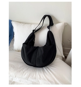 Macro shot of durable black canvas texture and adjustable strap on a crescent bag
