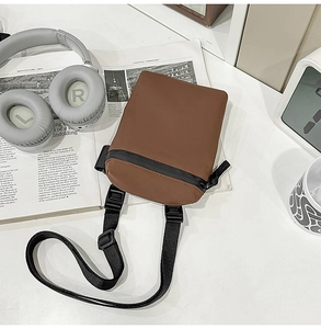 Detailed top view of a brown nylon crossbody phone bag with black strap and zipper