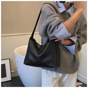 Detail of black pebbled leather texture on a stylish commuter hobo shoulder bag
