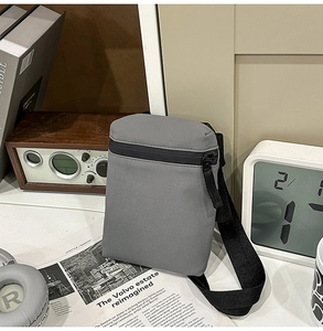 Detail of grey waterproof crossbody bag with high-quality zipper and wide strap