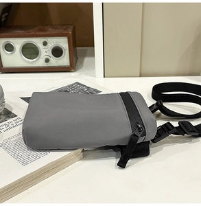 Detail view of grey nylon crossbody phone bag with black waterproof zipper and strap