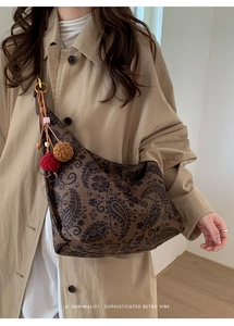 Detail of retro paisley canvas tote bag featuring bohemian pompom charms and wood beads