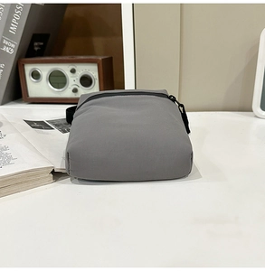 Macro view of grey waterproof nylon crossbody bag showing matte texture and zipper details