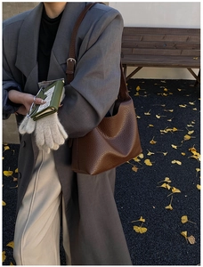 Detail of dark brown pebble leather texture and silver buckle on casual shoulder bag
